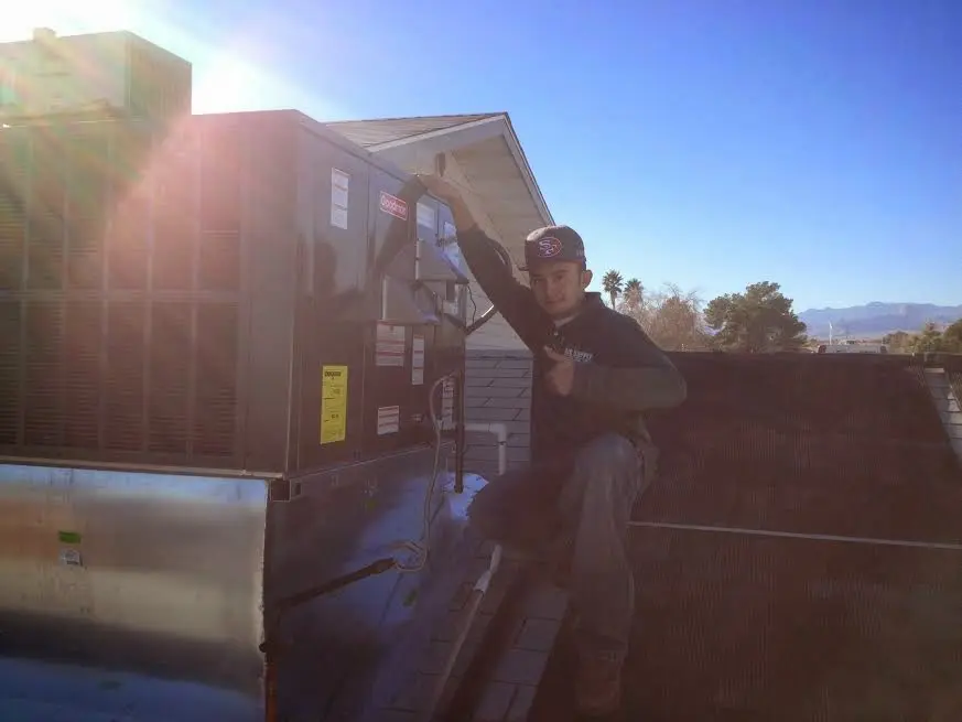 HVAC technician performing Air Duct Repair on a rooftop unit in Pasadena